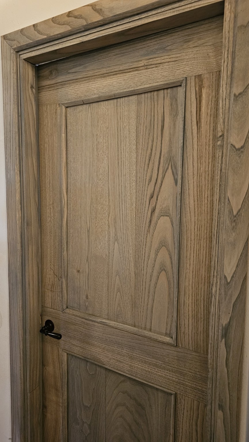 Bespoke timber panelled interior door with a dark handle